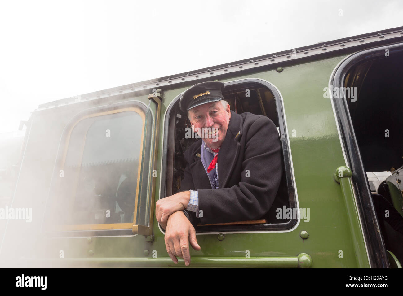 Steam locomotive driver smiling at his cab window, on the Severn Valley Railway, Bridgnorth UK Stock Photo