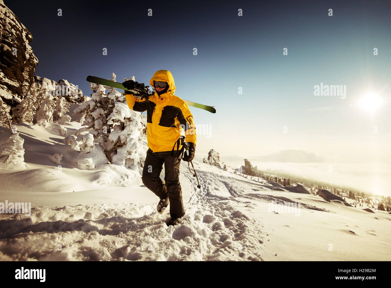 Snowboarder posing on blue sky backdrop in mountains Stock Photo