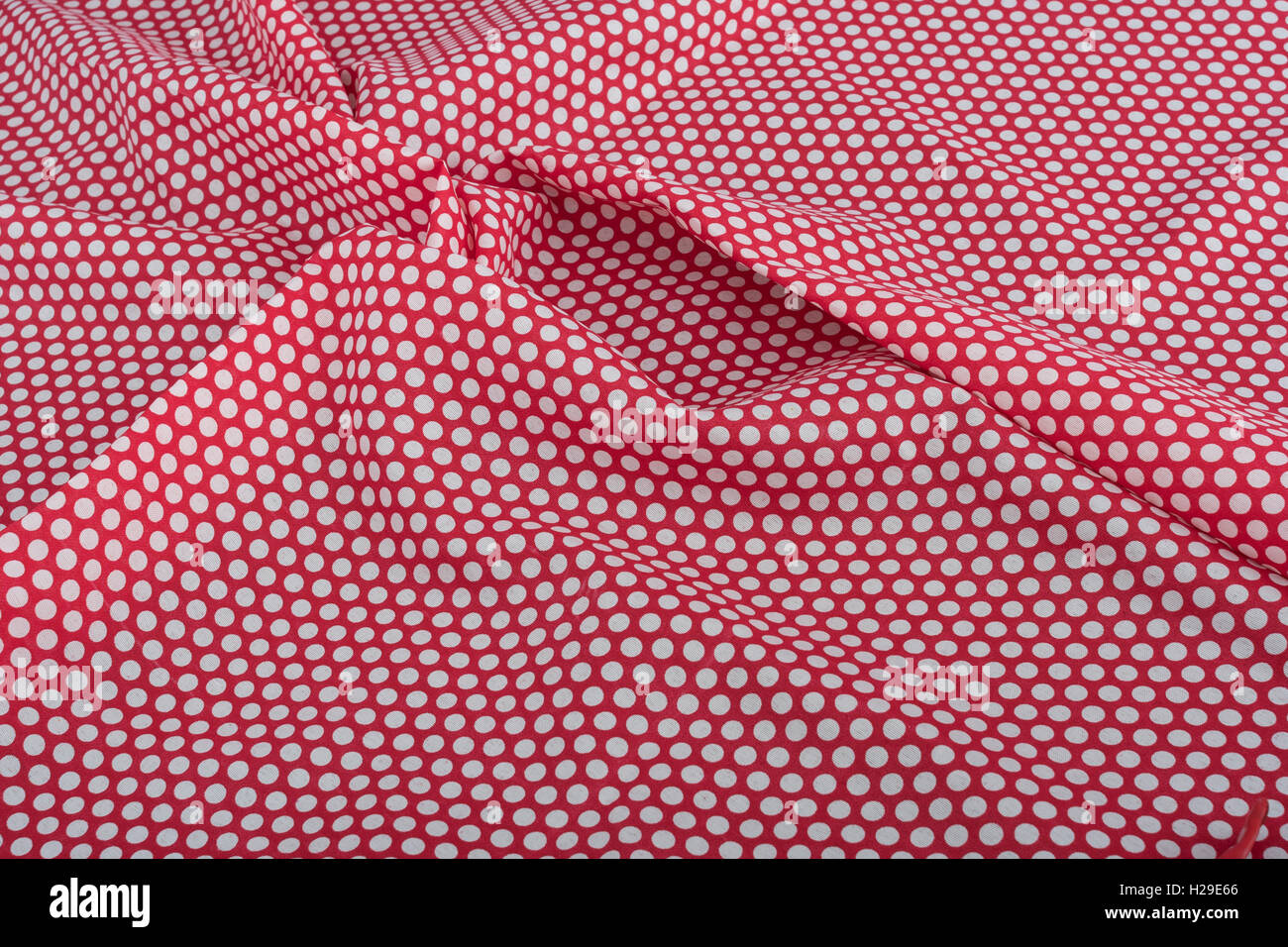 Abstract red-white polka dot cotton material. Concept 'International Dot Day' and perhaps a dotty personality, dotty person. Stock Photo