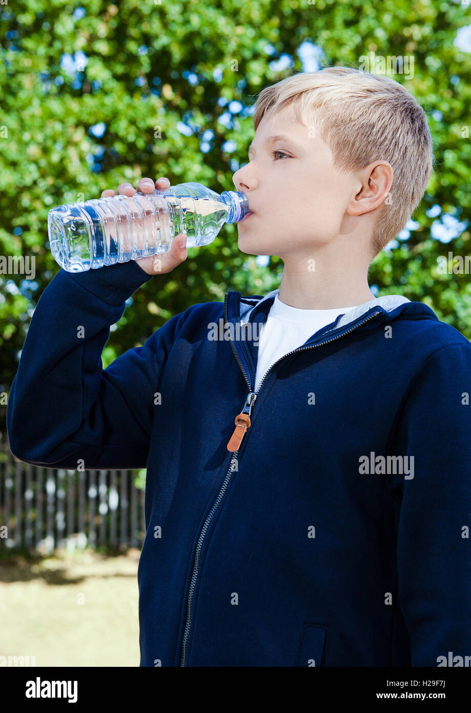https://c8.alamy.com/comp/H29F7J/young-teenage-boy-drinking-healthy-still-water-in-park-summer-time-H29F7J.jpg