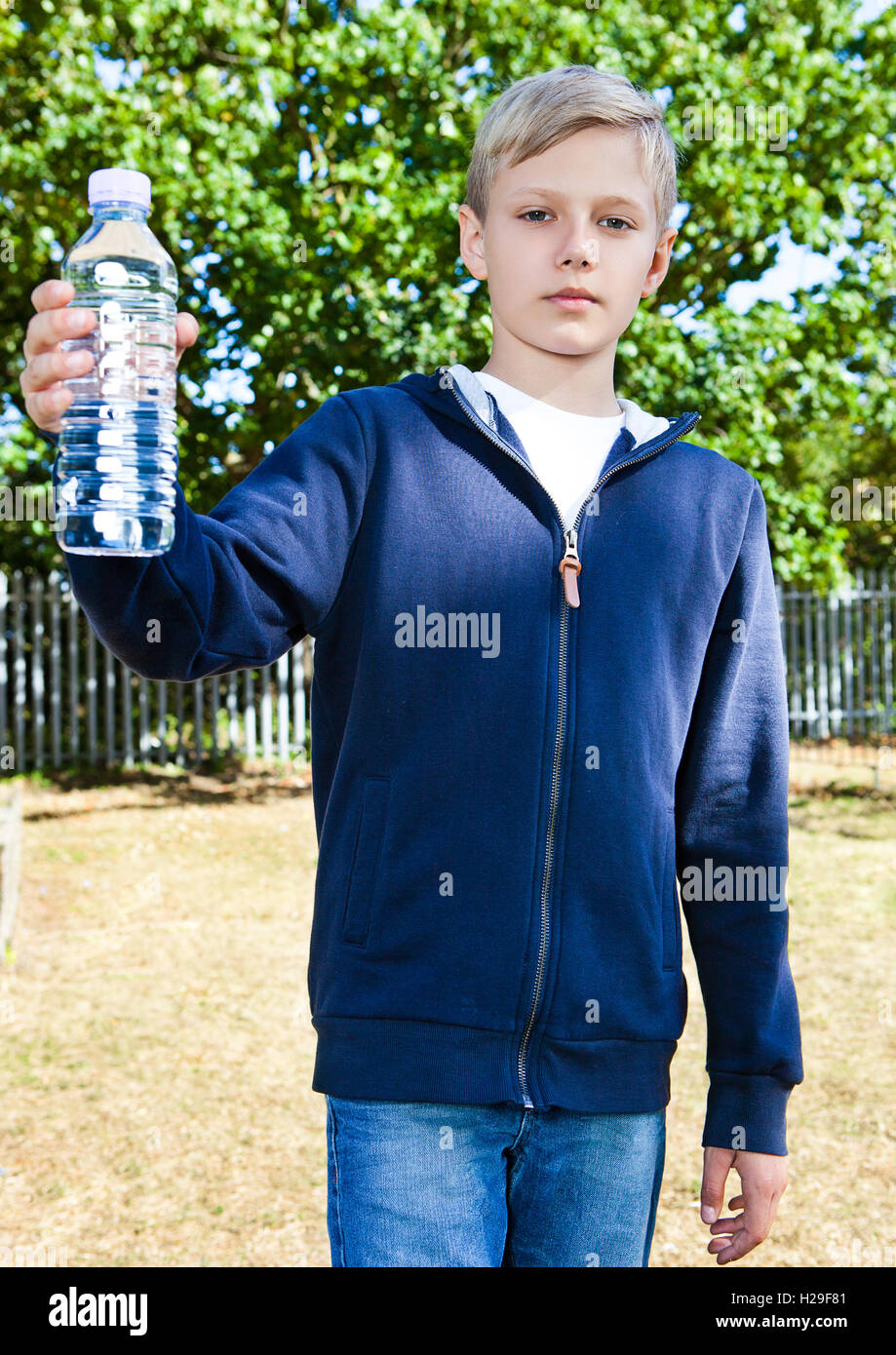 Young teenage boy with bottle of water in park Stock Photo - Alamy