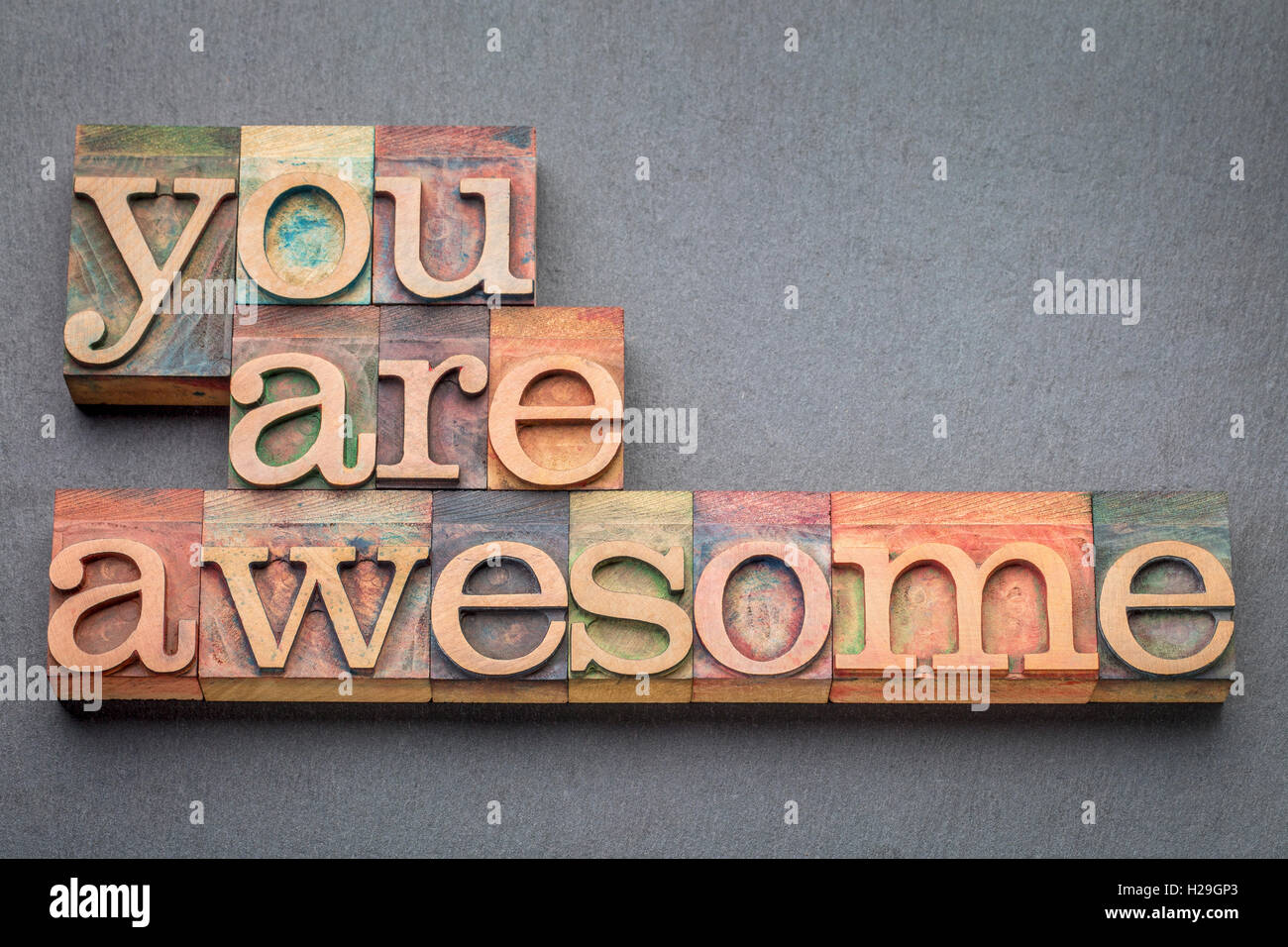 you are awesome word abstract in letterpress wood type blocks against gray slate stone Stock Photo