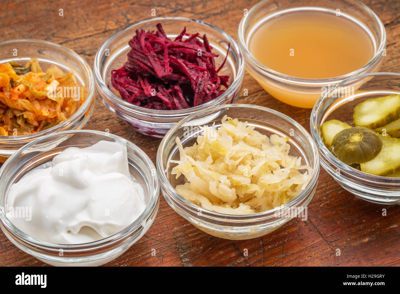 a sampler of fermented food great for gut health - glass bowls against wood Stock Photo
