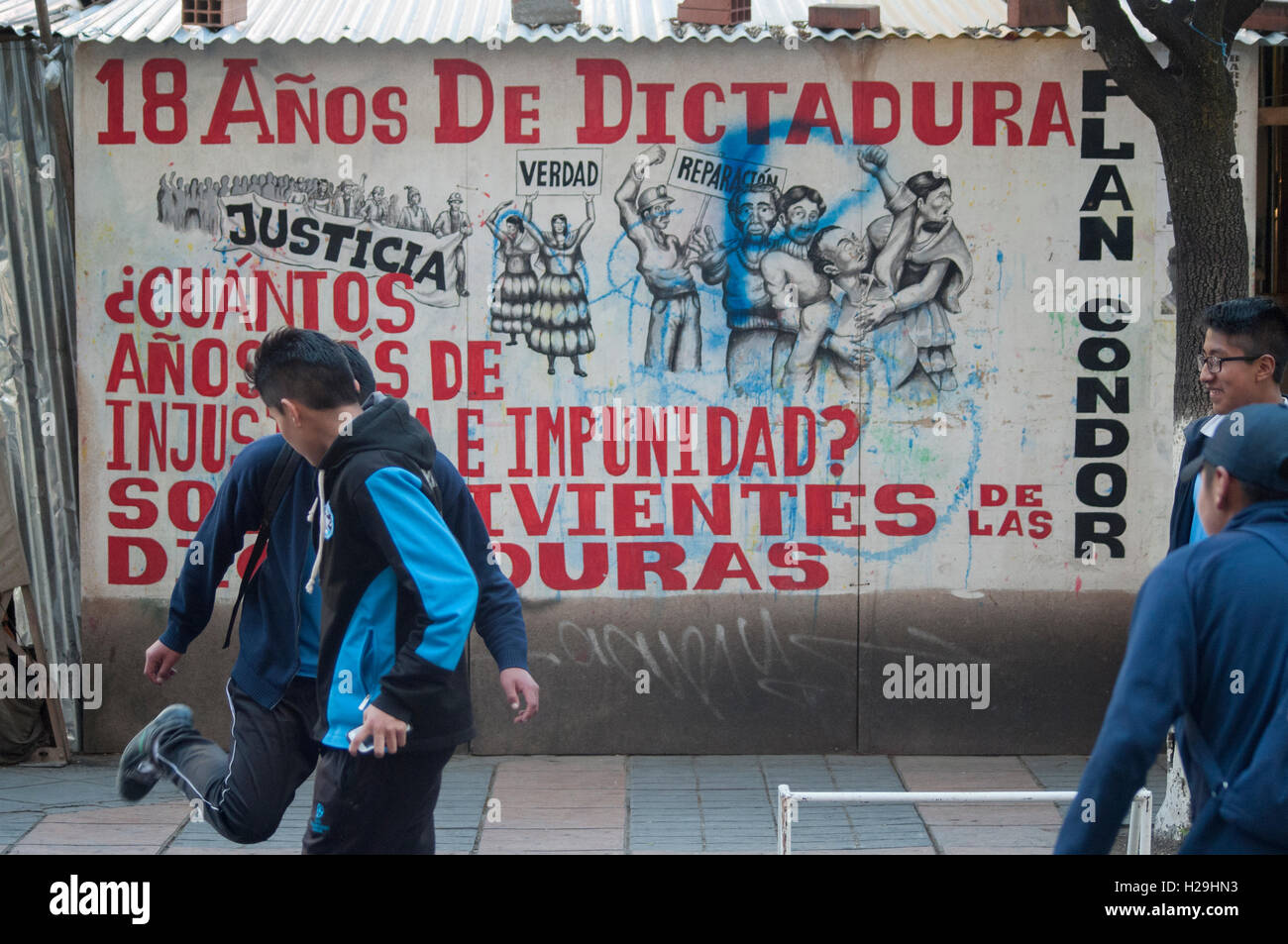 Young men play soccer in front of a political protest billboard in La Paz, Bolivia Stock Photo