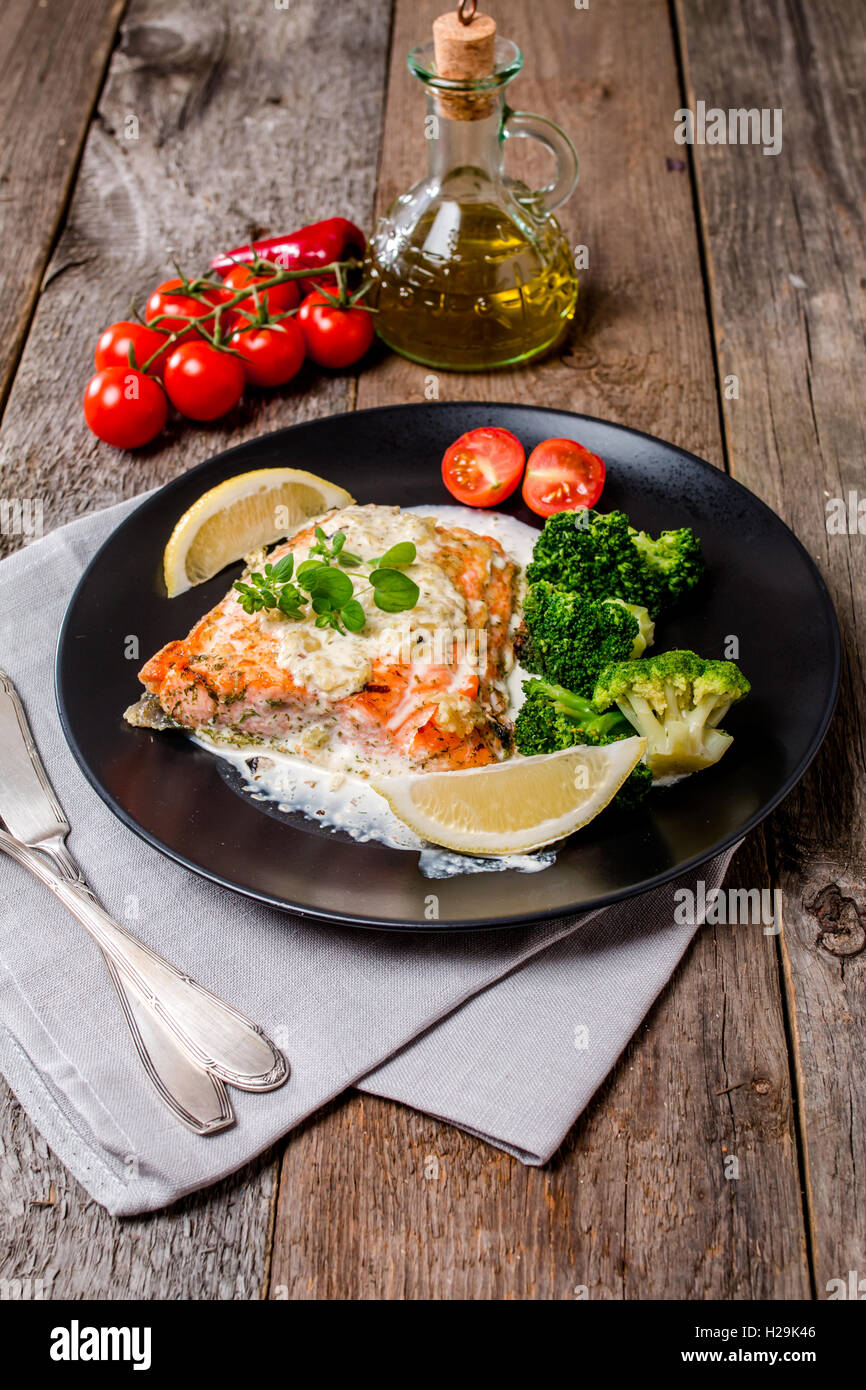 Grilled Salmon Steak with Broccoli, Cream sauce and Lemon Wedges on ...