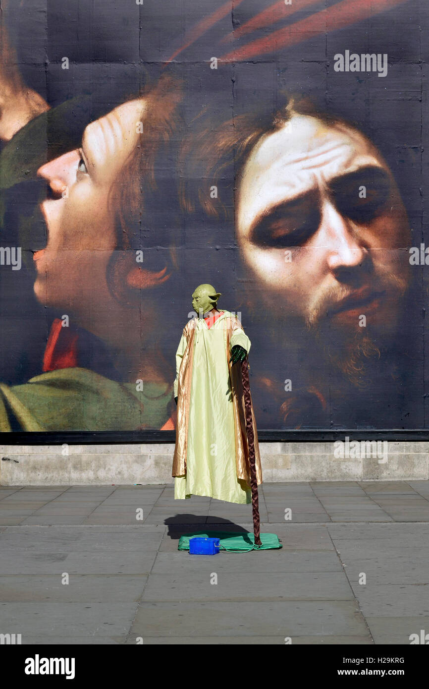 London, England, UK. Human statue in Trafalgar Square - Yoda (Star Wars) 'floating' in front of the National Gallery (poster for Stock Photo