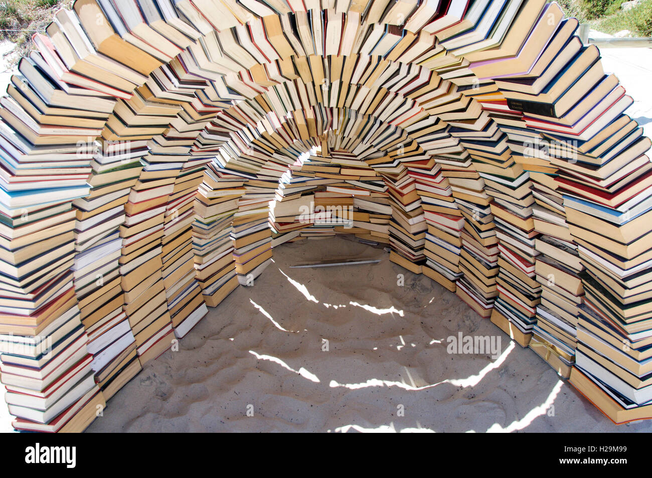 Arched book shelter sculpture at Sculptures by the Sea in sand at
