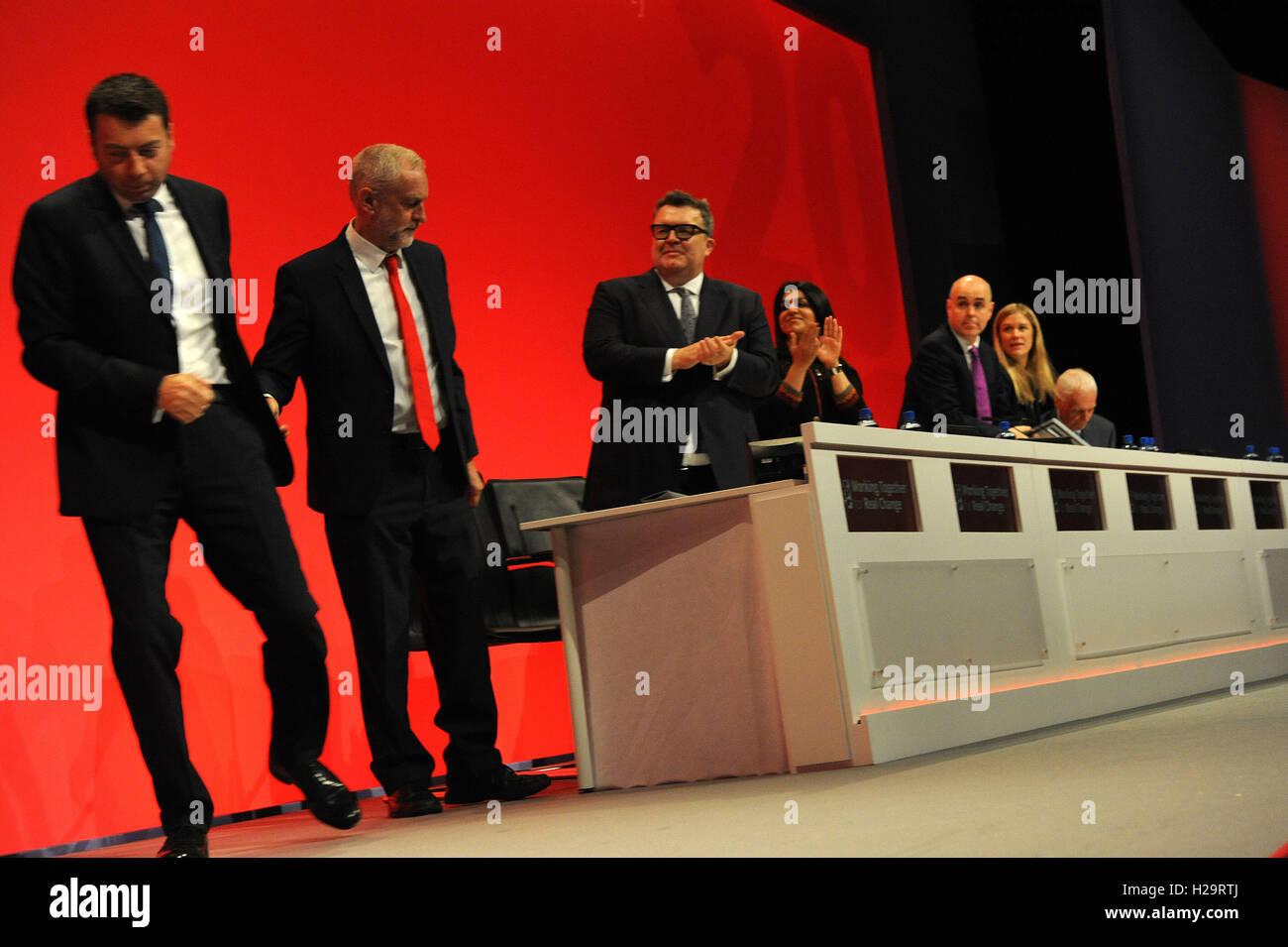 Liverpool, England. 25th September, 2016.  Ian McNicol (L), party general secretary, leaves the stage having shaken hands with Labour leader Jeremy Corbyn (2nd L),  during the first day of the Labour Party annual conference at the ACC Conference Centre. On the morning of the first day of the conference there will be reports from the general secretary, the national policy forum and on digital and party organisation. This conference is following Jeremy CorbynÕs re-election as labour party leader after nine weeks of campaigning against fellow candidate, Owen Smith. This is his second leadership v Stock Photo