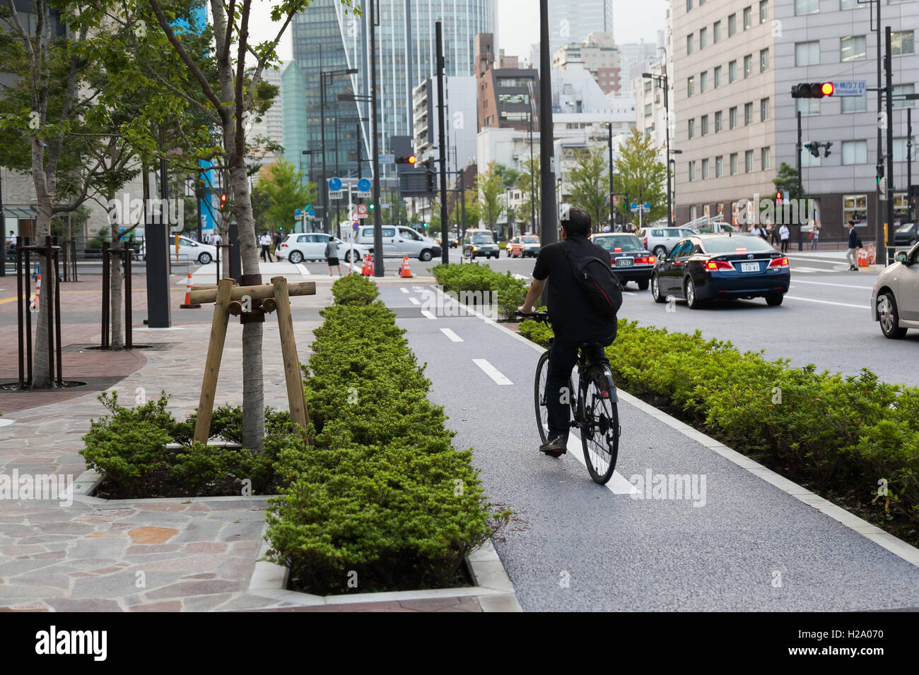 A man on a bicycle rides along newly opened section of Loop Road No. 2 between Shimbashi and Toranomon on September 26, 2016, Tokyo, Japan. When complete the new road will connect the Shimbashi station area with the government buildings and offices of Toranomon Hills. The boulevard is wide by Tokyo standards including 13m sidewalks and bike lanes and it is hoped that the area will attract many foreign visitors especially during the 2020 Olympic Games. © Rodrigo Reyes Marin/AFLO/Alamy Live News Stock Photo