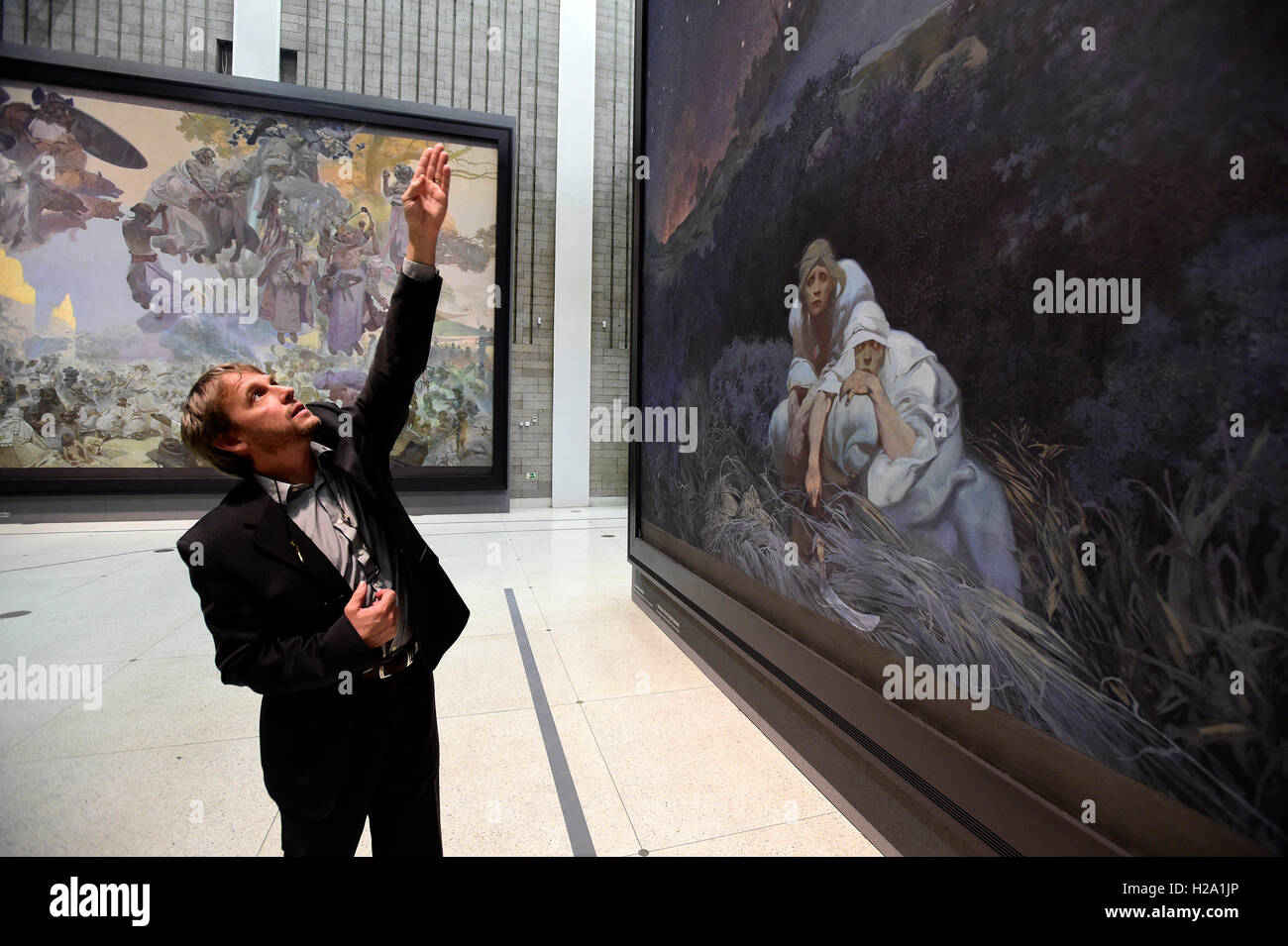 Prague, Czech Republic. 26th Sep, 2016. The Slav Epic cycle of paintings by Czech Art Nouveau artist Alfons Mucha (1860-1939) will fly to Tokyo in February where it will be displayed as of March 7, and then it will move to China as of mid-2017, Prague City Gallery director Magdalena Jurikova told reporters in Veletrzni (Trade Fair) Palace, Prague, Czech Republic, September 26, 2016. Restorer Tomas Berger points to the painting. © Roman Vondrous/CTK Photo/Alamy Live News Stock Photo
