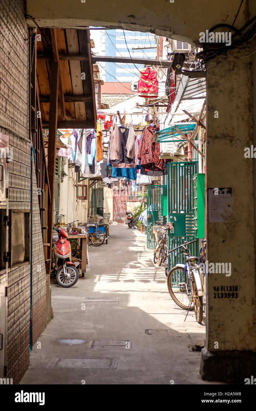 Hutong with hanging laundry and parked bicycles in Shanghai, China Stock Photo