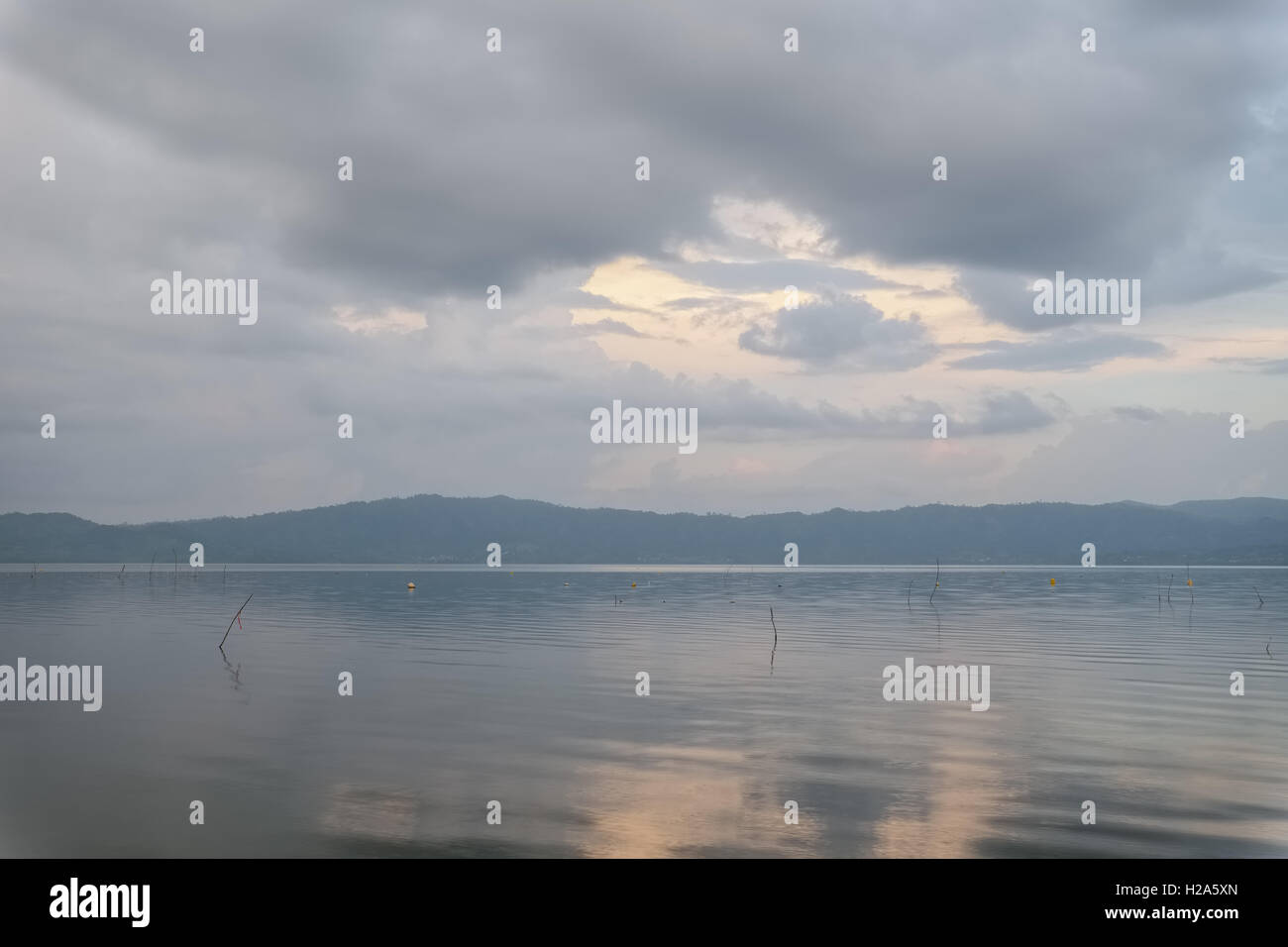 Pastel color sky and water at sunset over lake at Lake Bosomtwe in Ghana Stock Photo