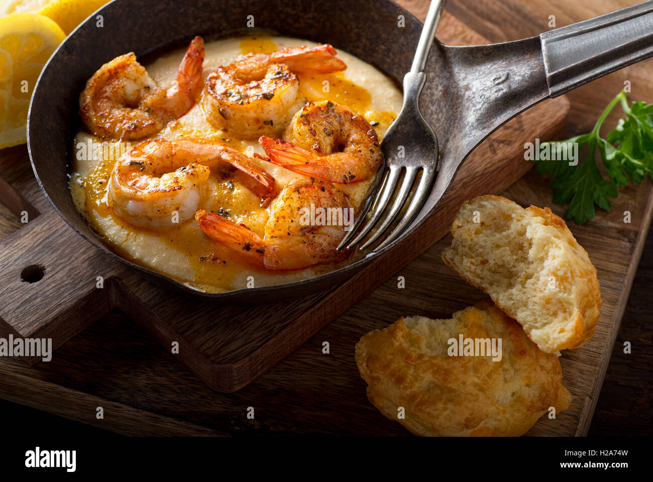 A pan of delicious fresh homemade cajun style shrimp and grits with cheddar biscuit. Stock Photo