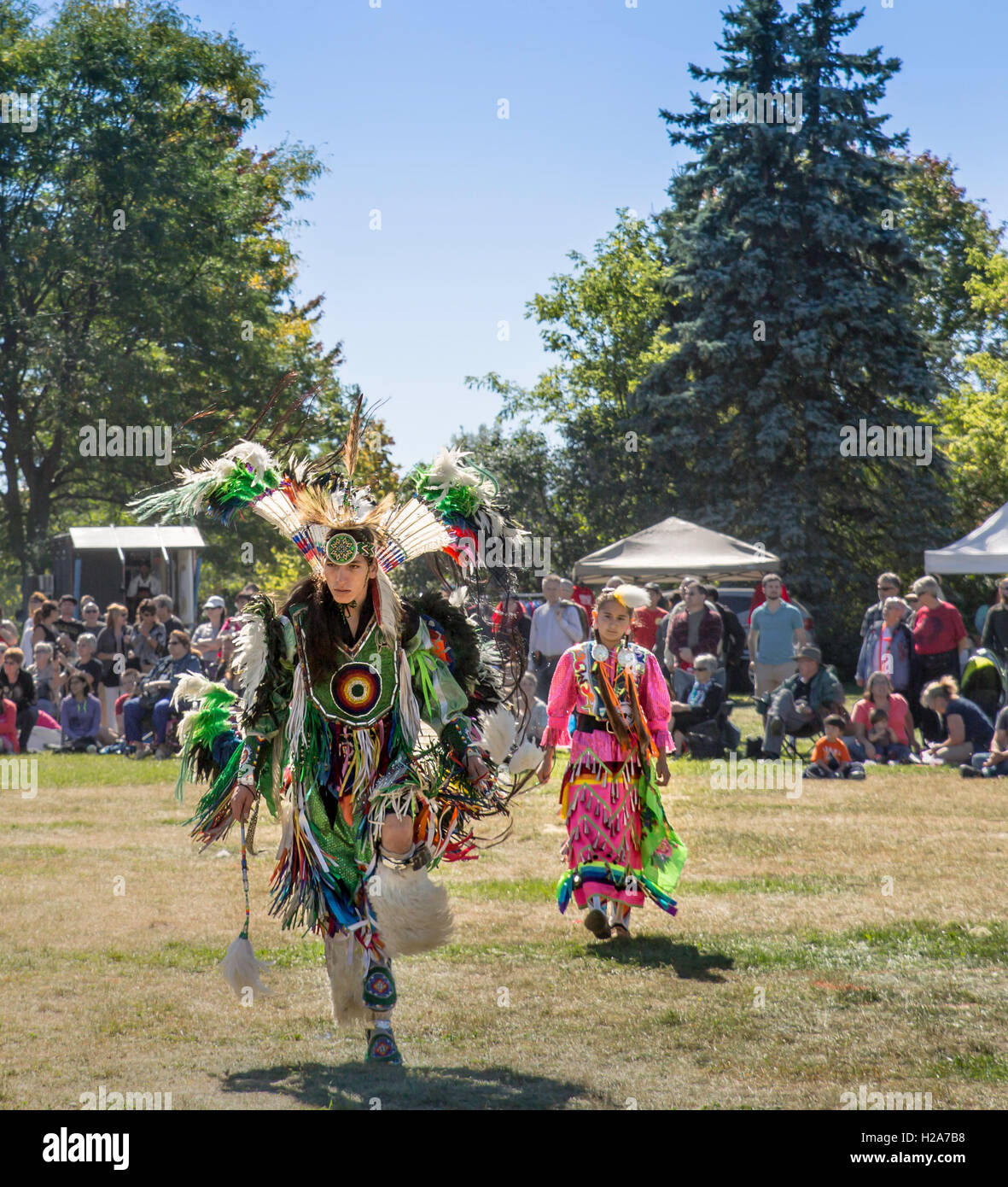 Dancers in full native costume dance to the beat of drums in the 13th annual pow wow at Waterloo Park, Waterloo, Canada. Stock Photo