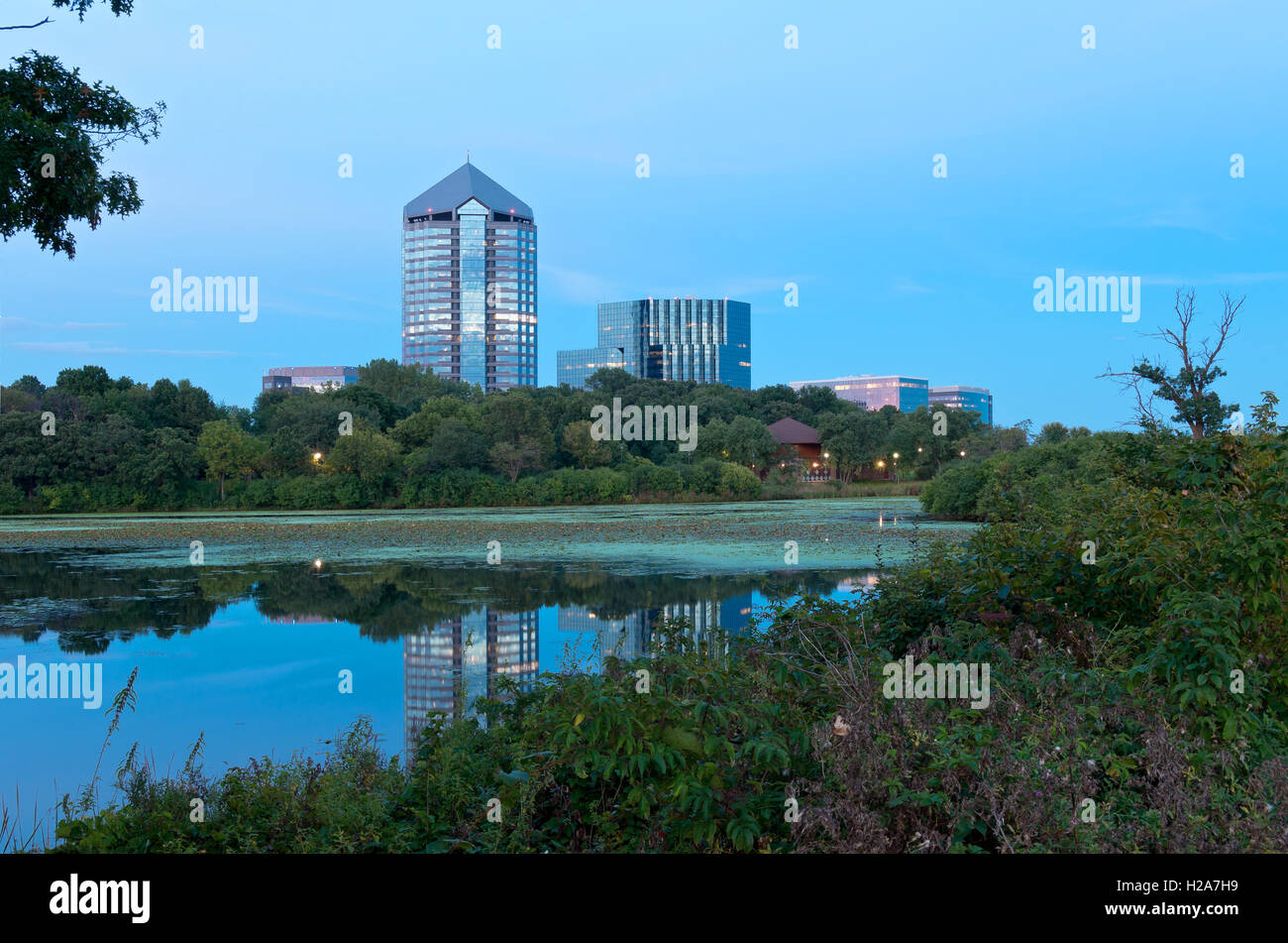 tree-lined mount normandale lake park and offices with reflections on water in bloomington minnesota Stock Photo
