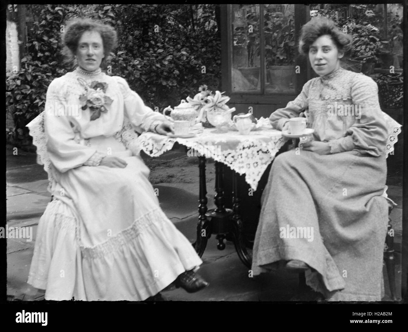 Two splendidly-dressed ladies having tea C1910.Photo by Tony Henshaw Stock Photo
