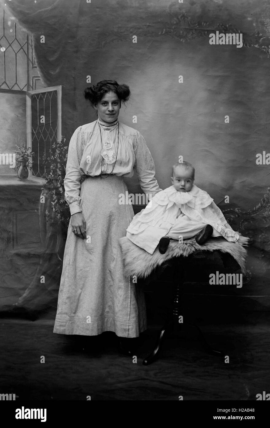 Woman poses with baby, Newark Area c1910.  Further details for entire collection in the box of 50 slides -  as written in glass slide box 'Ann Swain 1910, Annie & Georgie Betts 1910, Mr Starbuck, Lily & Ethel 1909, Kate & Family, Georgie & Tommy Holgate, Group at Newark 1909, Belvoir Castle, Mrs Limb 1910.'  Photo by Tony Henshaw Stock Photo