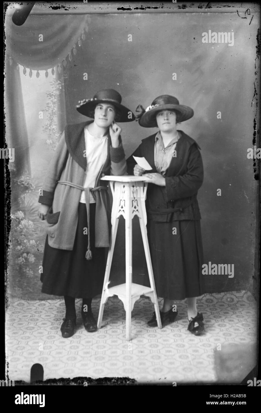 (Unrestored Version) Two Edwardian ladies in fashion designs of the time during a flashed studio portrait c1915. Photo by Tony Henshaw Stock Photo