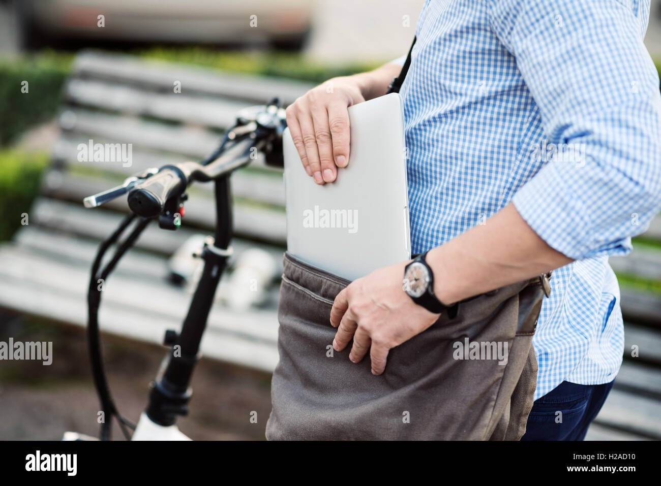 Handsome sportive man taking out laptop from the bag Stock Photo - Alamy