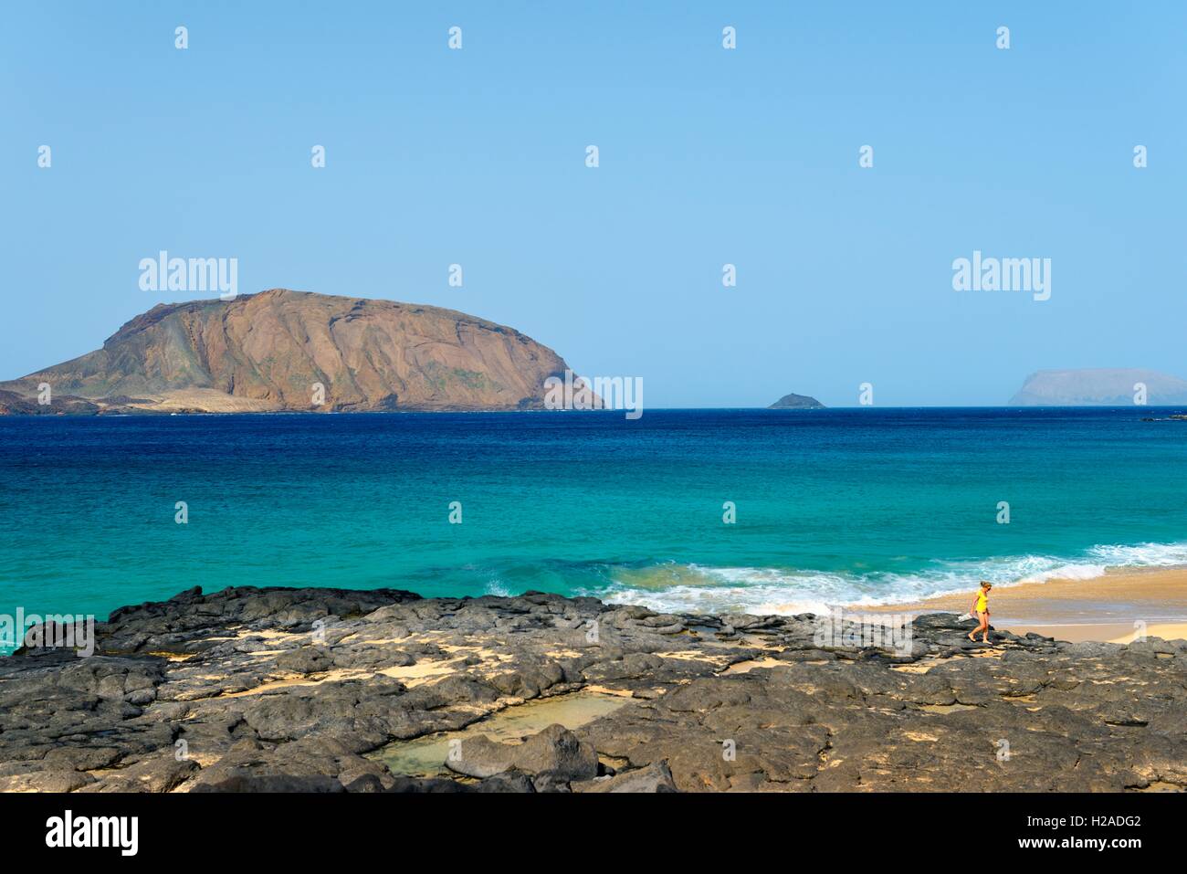 Lanzarote, Canary Islands. Rocks and beach of Playa de las Conchas on Isla Graciosa, Lanzarote. Toward island of Montana Clara Stock Photo