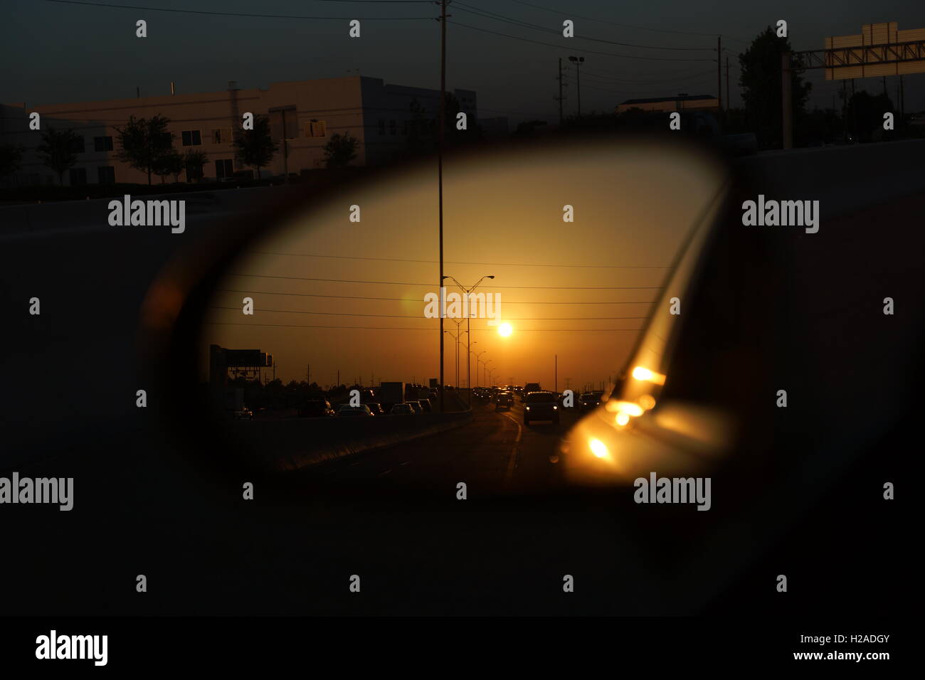 side mirror sunrise reflection in traffic on freeway Stock Photo