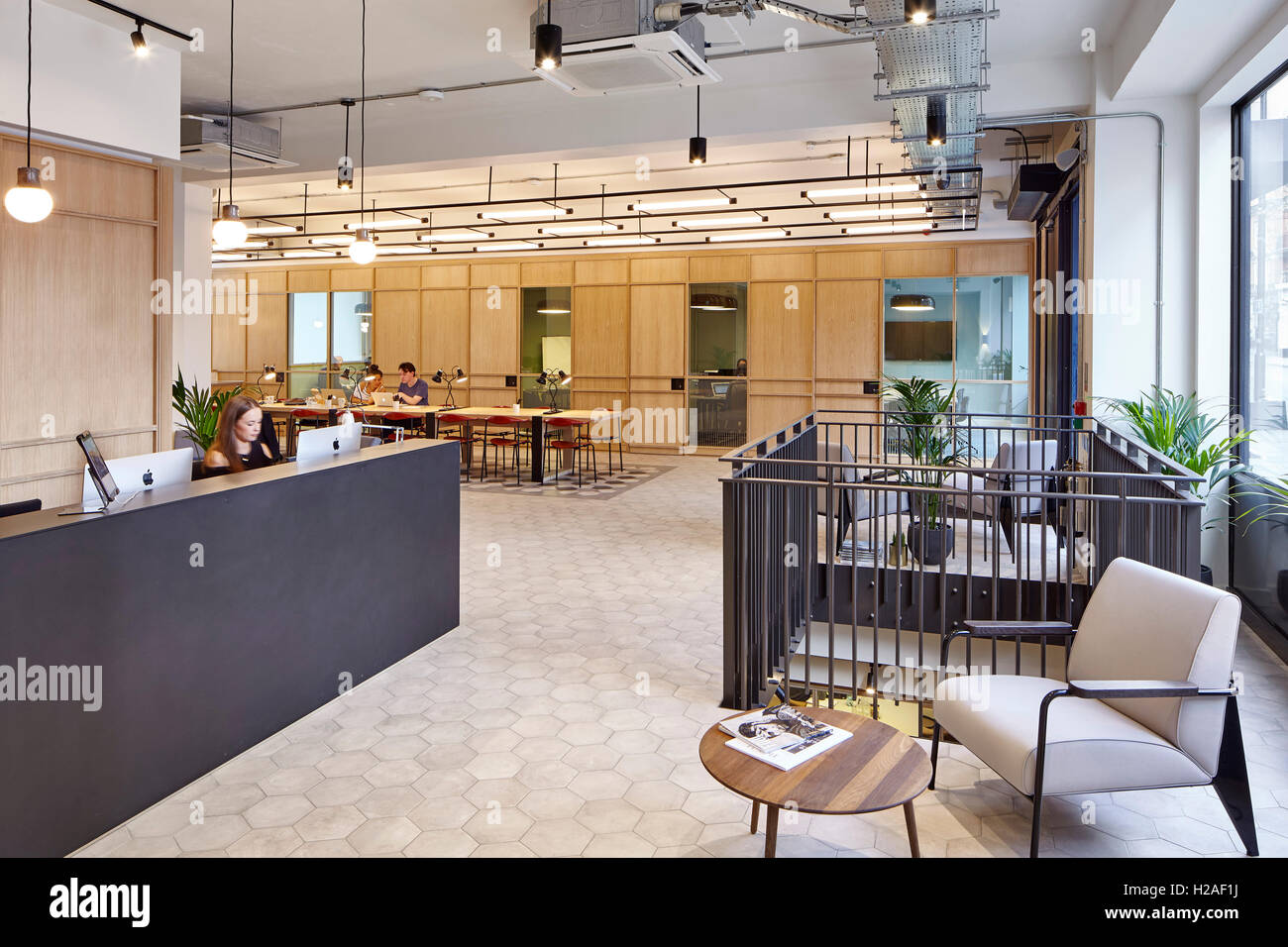 Reception desk with open work space and offices in the background. The Smiths Building, London, United Kingdom. Architect: Stiff + Trevillion Architects, 2016. Stock Photo