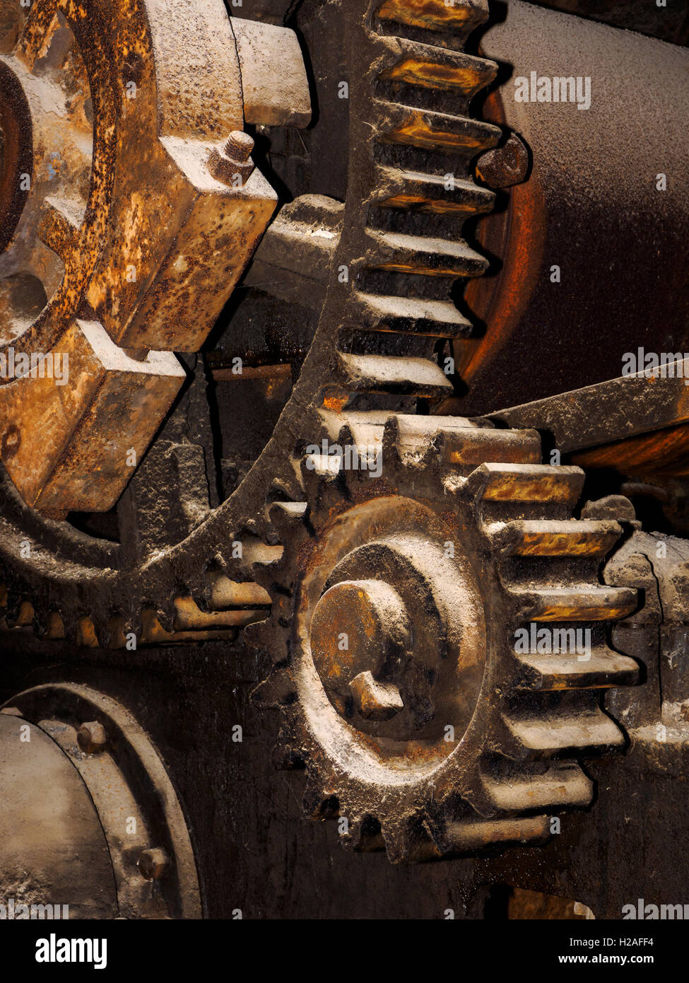 Huge iron cog wheels, part of the drive mechanism of a brickworks machine. Stock Photo