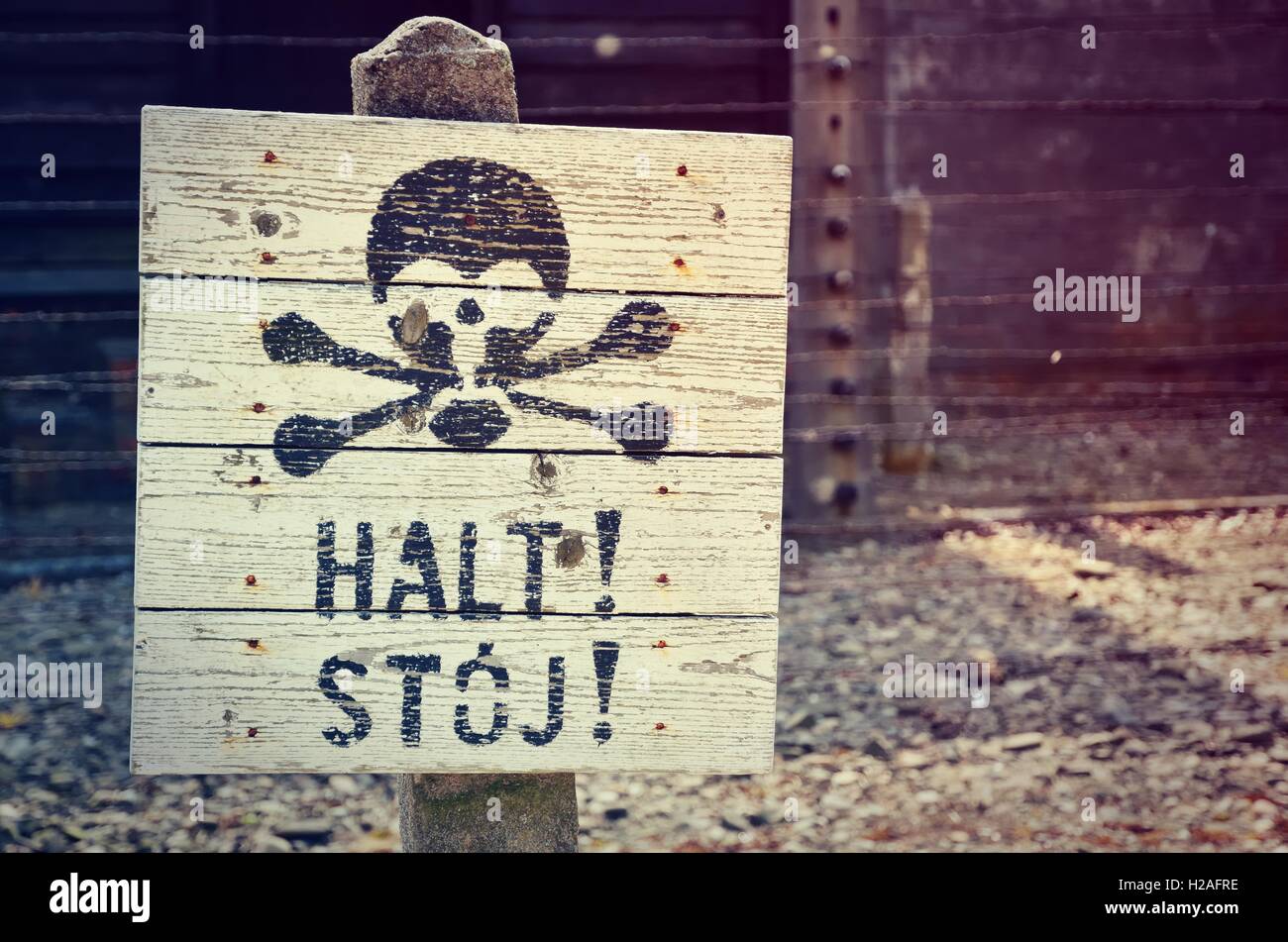 Sign warning of the danger of the fence in concentration camp Auschwitz-Birkenau in Oswiecim, Poland. Stock Photo