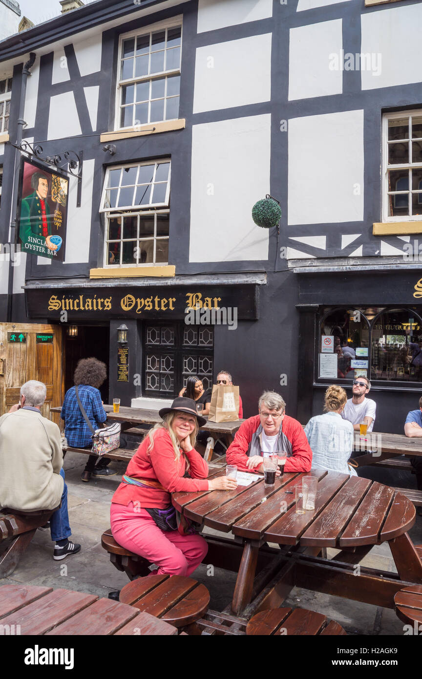 A man and woman drinking outside Sam Smith's Sinclair's Oyster Bar, Cathedral Approach, Manchester, England Stock Photo