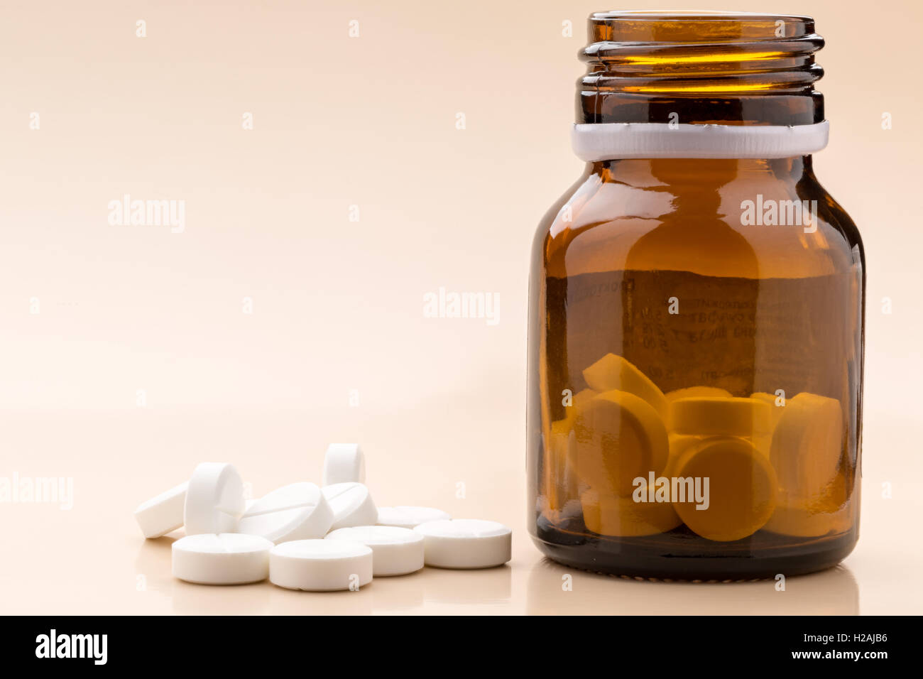 Round white pills and glass pill bottle Stock Photo