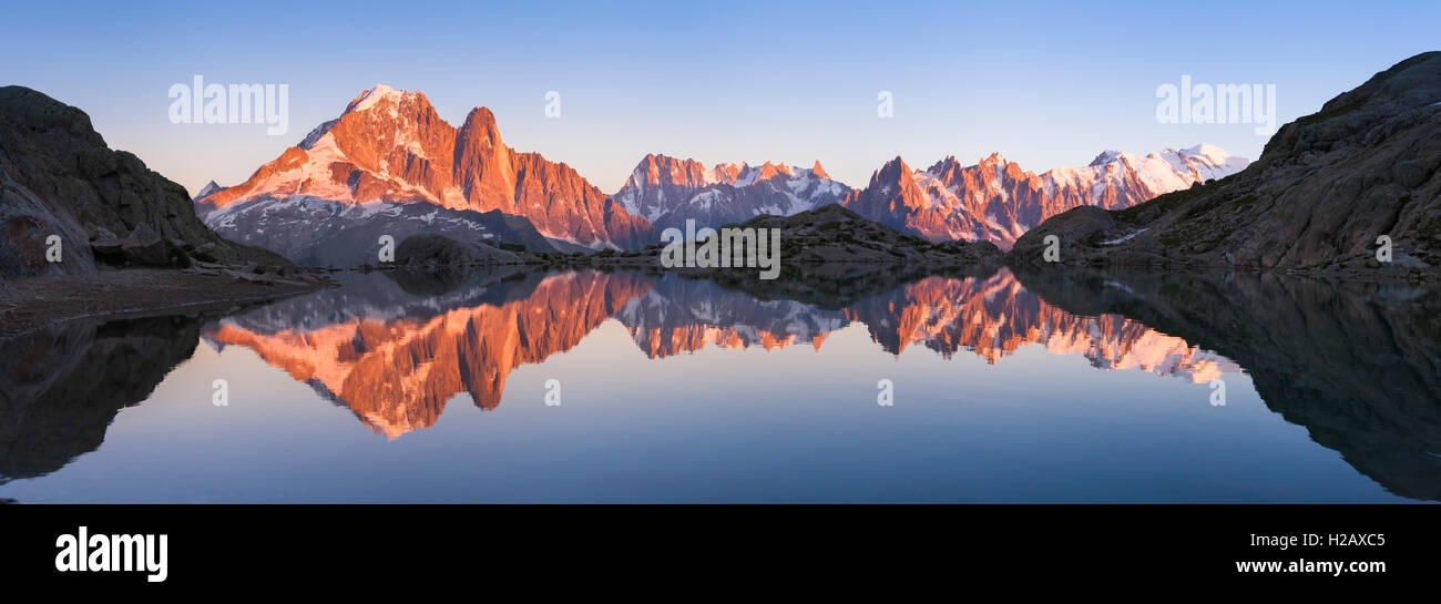 Beautiful panorama of Alps mountain range with sunset light reflecting in a lake near Chamonix Stock Photo