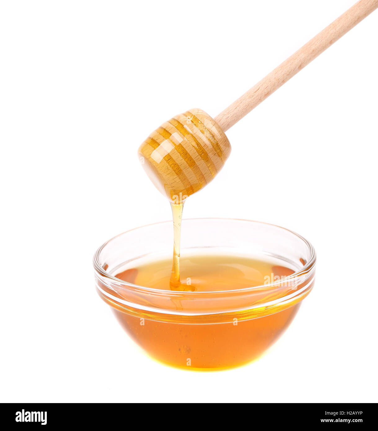 Honey dripping from a wooden dipper Stock Photo
