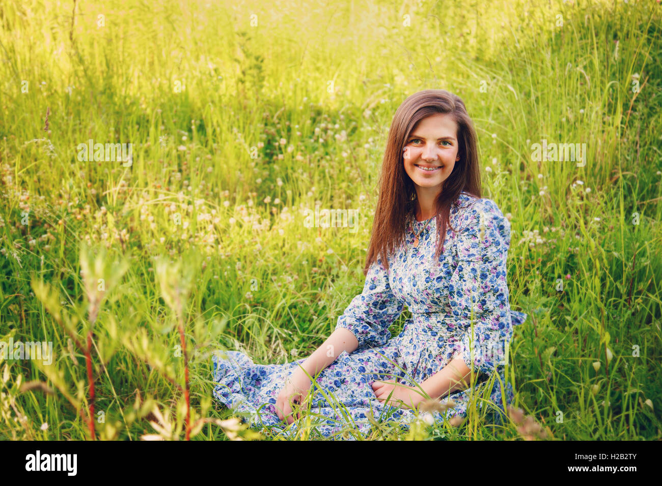 Portrait of a young smiling woman on nature in the grass Stock Photo ...