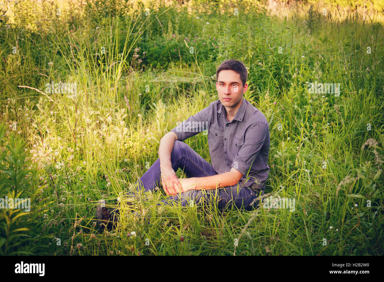 Portrait of a young man on nature in the grass Stock Photo - Alamy