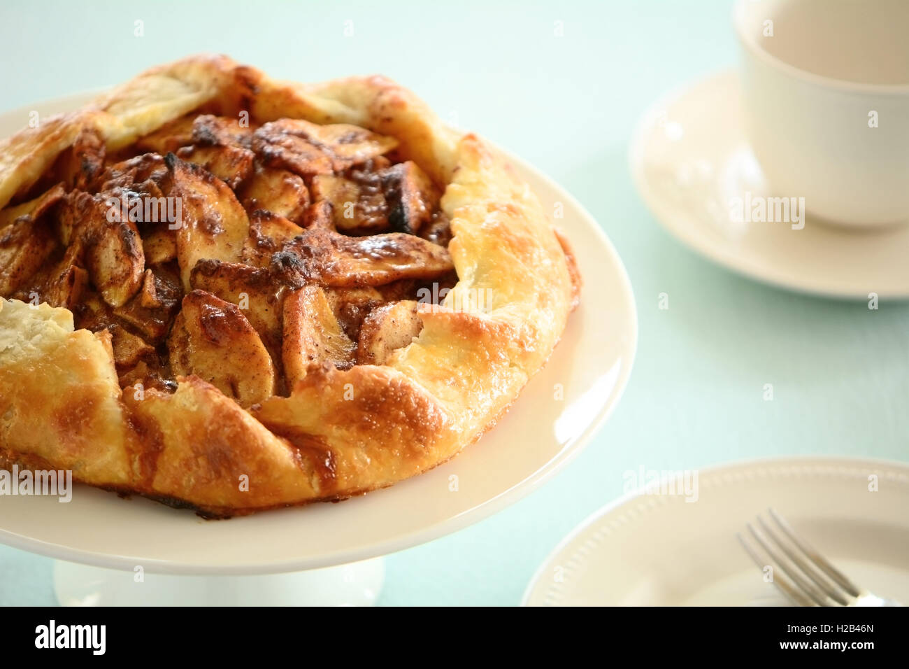 Fresh home made apple galette drizzled with salt caramel sauce on cake stand in horizontal format Stock Photo