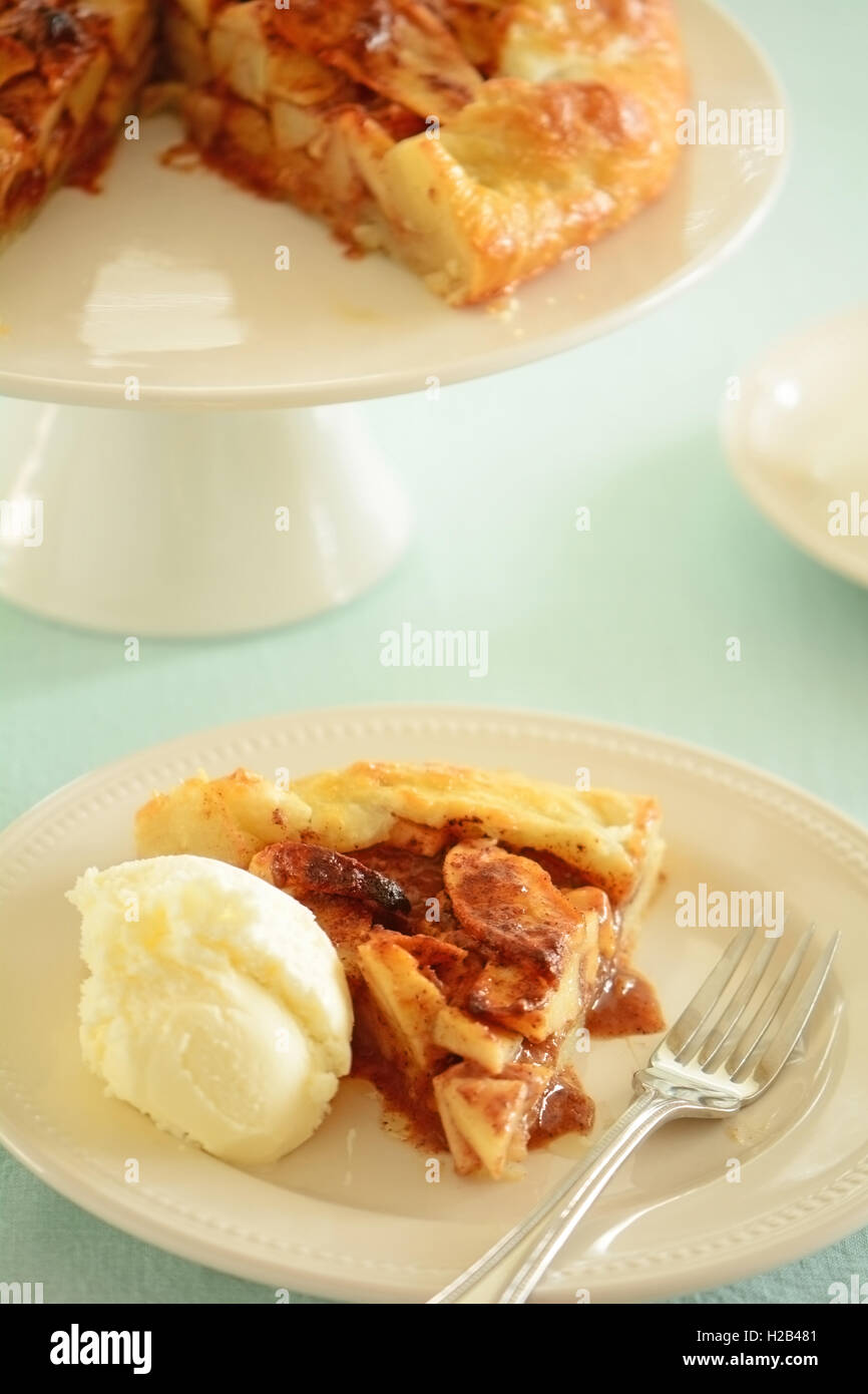 Fresh home made apple galette right from the oven on cake stand in vertical format Stock Photo