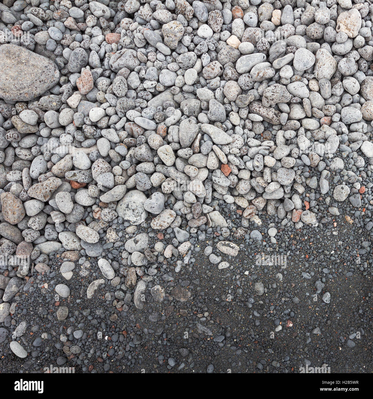 contrast between gray stones and volcanic black sand on the beach of El Gulfo Lanzarote Stock Photo
