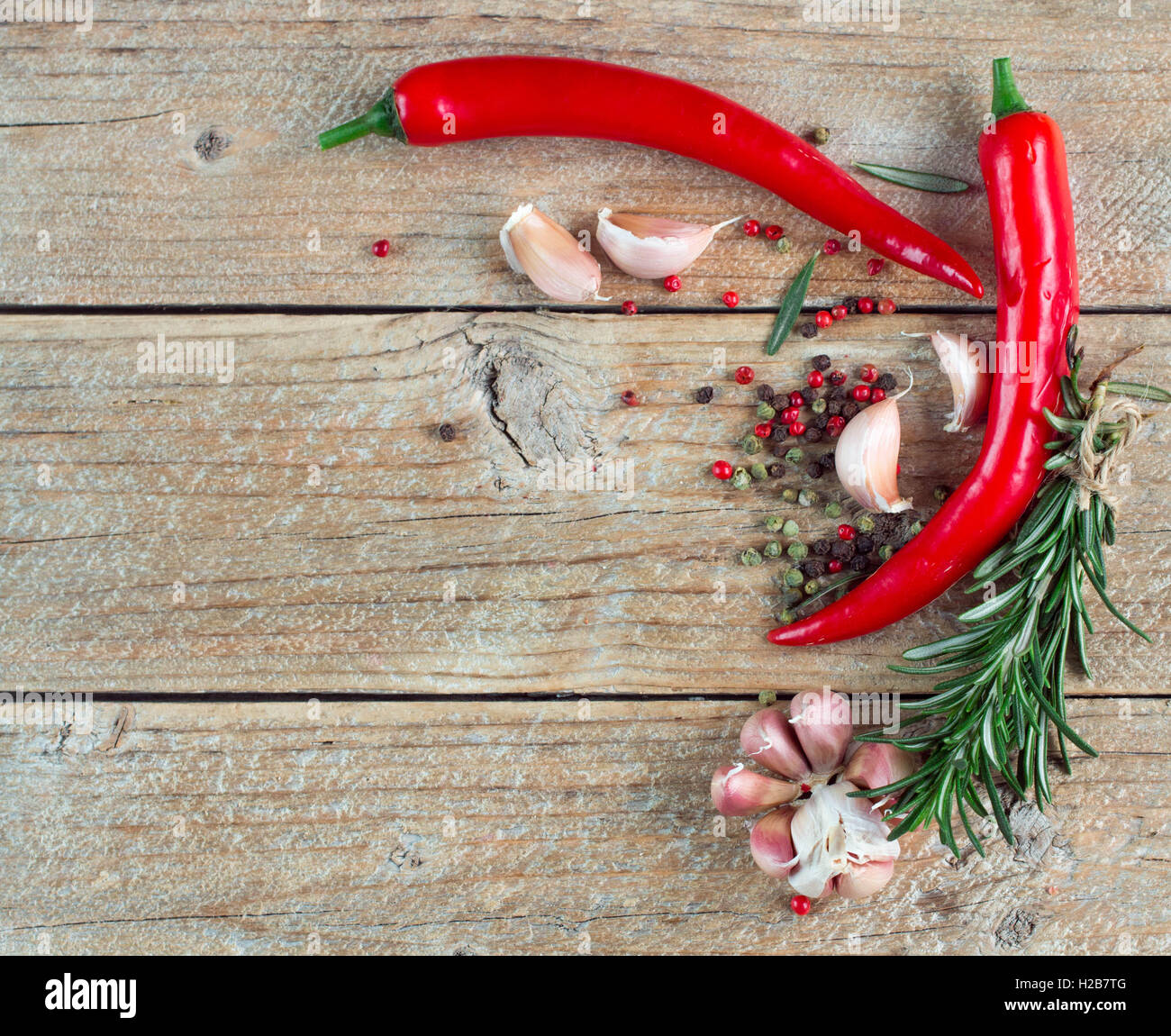 Condiments and spices - salt, rosemary, garlic, pink and black pepper, chilli. Selective focus. Rustic style Stock Photo