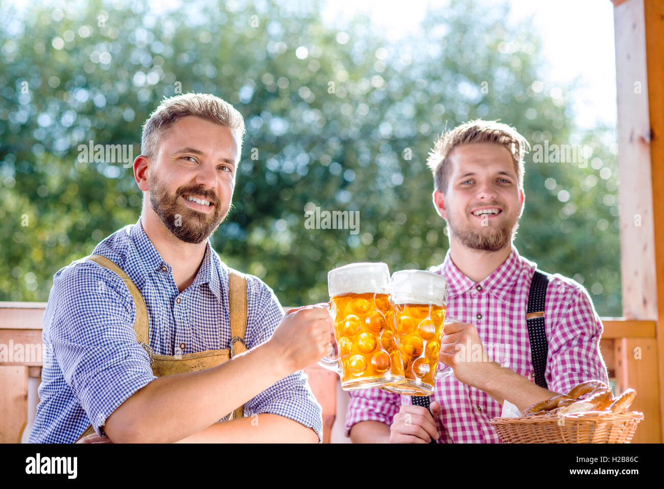 Men in traditional bavarian clothes holding mugs of beer Stock Photo