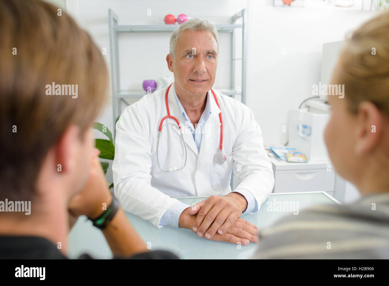 Handsome doctor listening young hi-res stock photography and images - Alamy