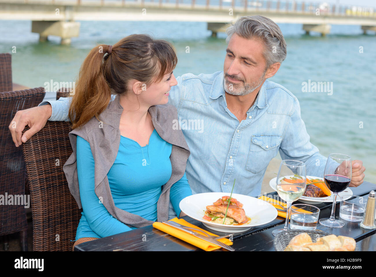 Couple dining outside in riverside restaurant Stock Photo - Alamy