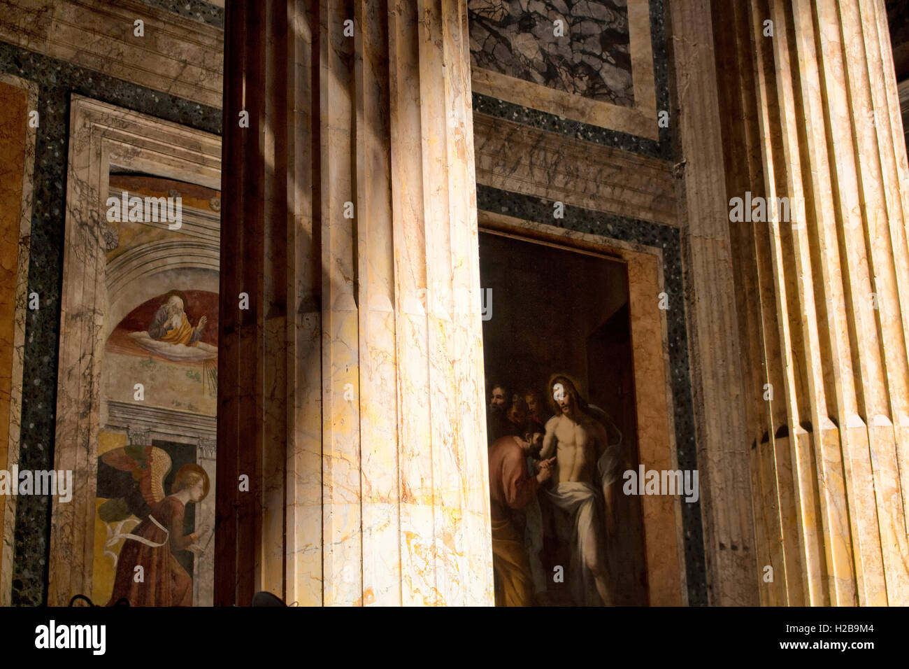 View of inside of Pantheon. A column and paintings behind it are in the view. Light coming from top creates dramatic ambiance. Stock Photo