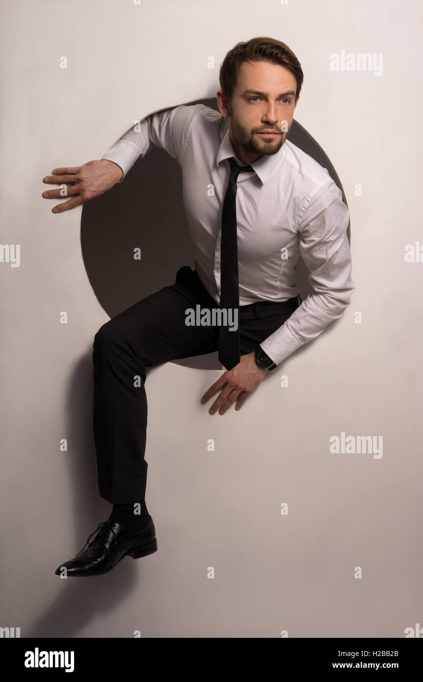 Businessman climbing out of a circular hole Stock Photo - Alamy