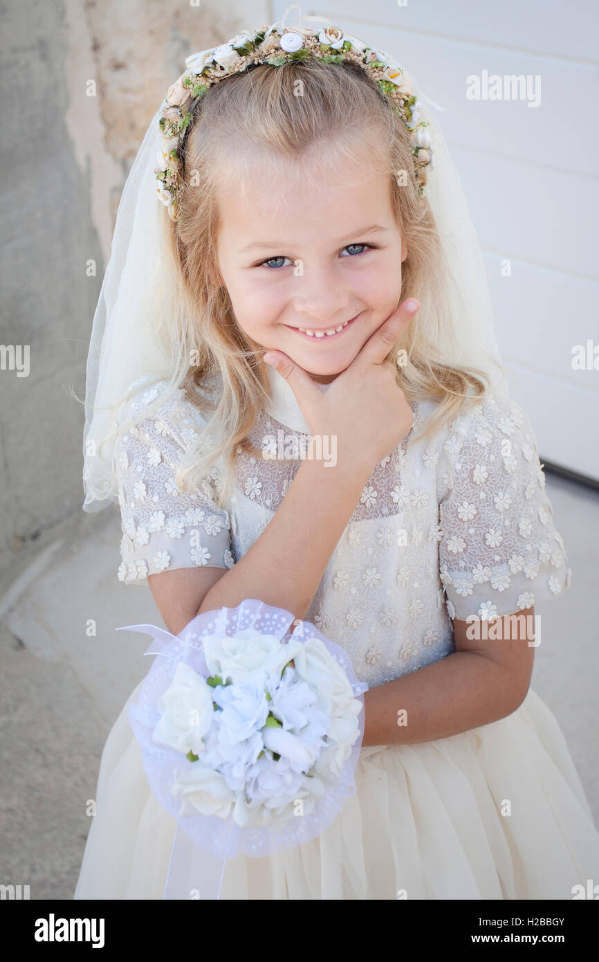 Girl in holy communion dress and veil Stock Photo - Alamy