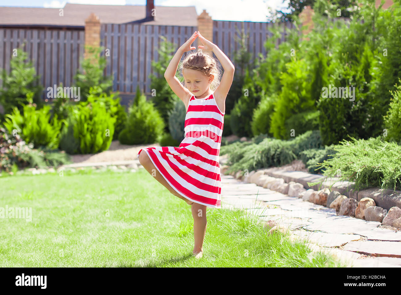 https://c8.alamy.com/comp/H2BCHA/little-adorable-girl-standing-in-a-yoga-pose-on-one-leg-H2BCHA.jpg
