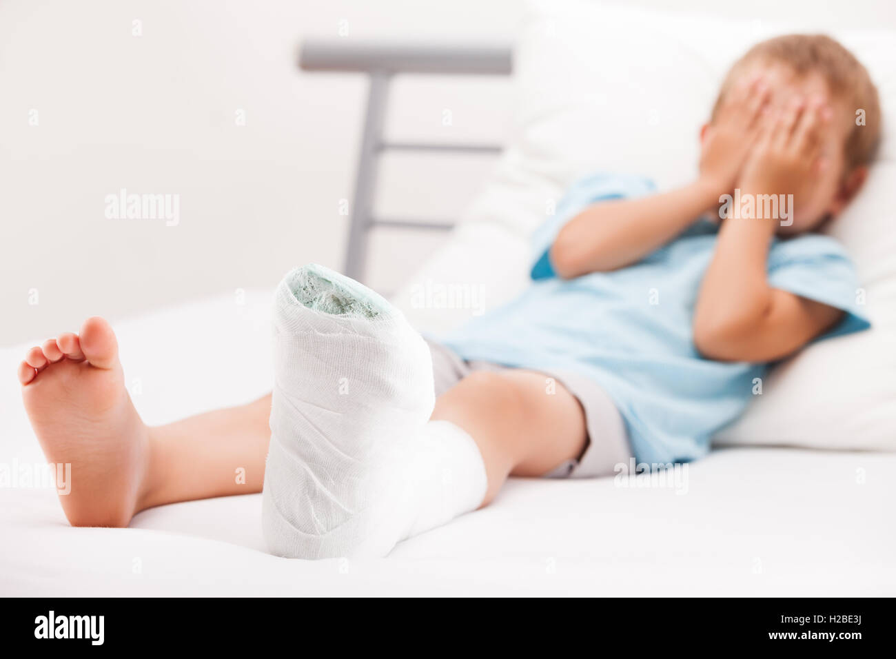 Little child boy with plaster bandage on leg heel fracture or br Stock Photo