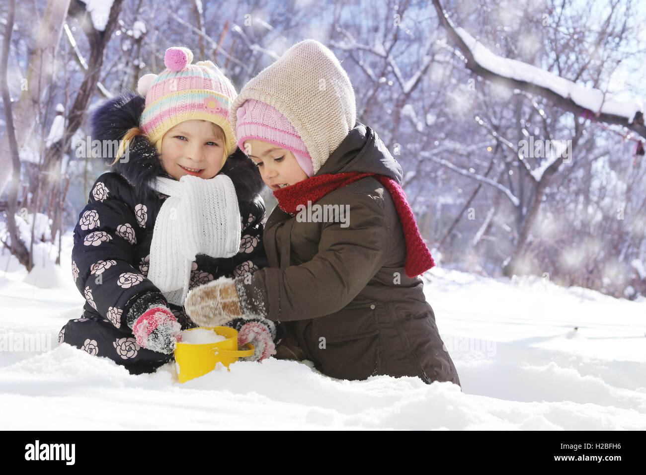Happy girls playing in snowy park Stock Photo - Alamy
