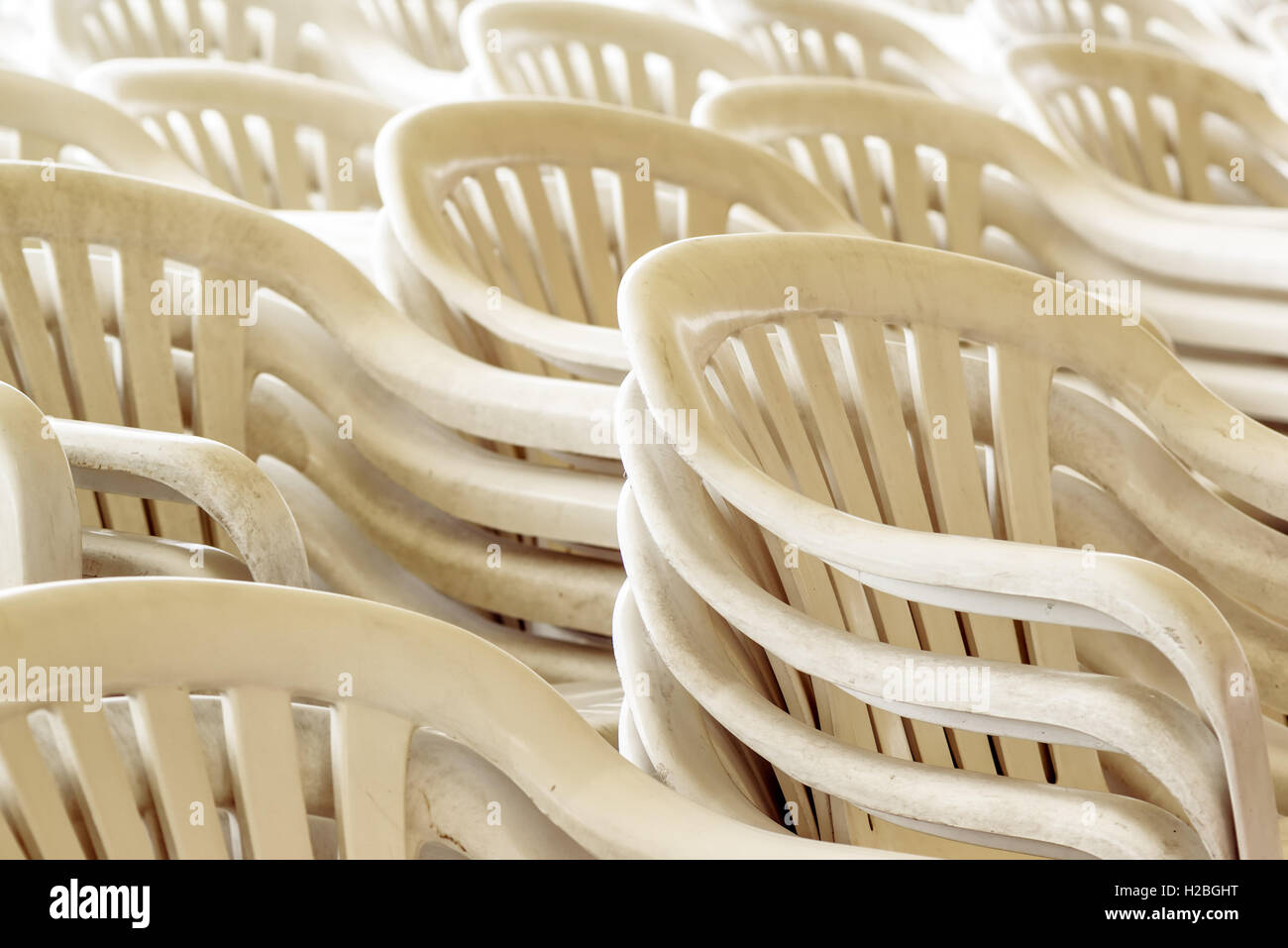 Stacked plastic chairs outdoors, selective focus detail Stock Photo