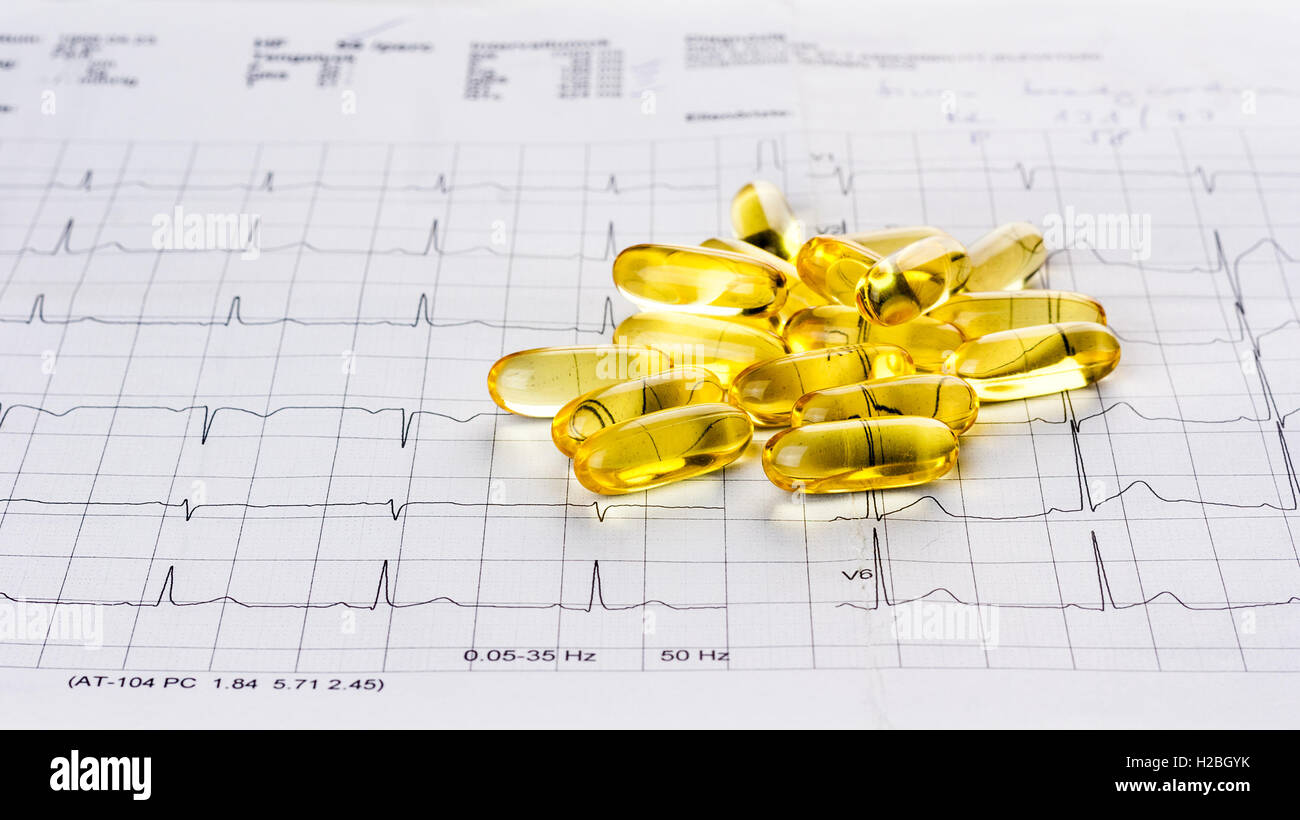 Omega 3 gel capsules on an ecg test result paper background Stock Photo