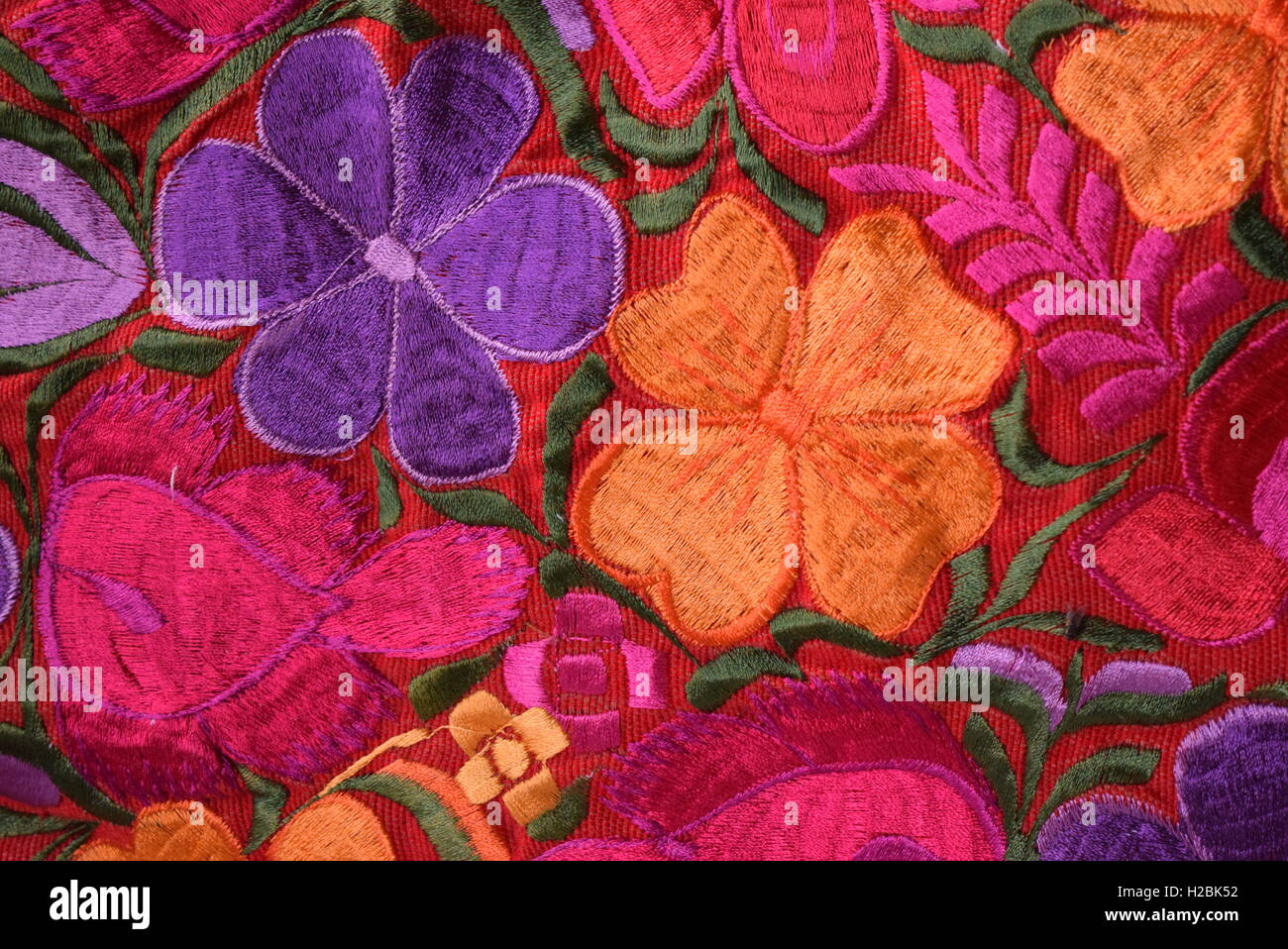 Texture: South American hand made colorful fabric with traditional patterns of flowers & design, Antigua, Guatemala. Stock Photo